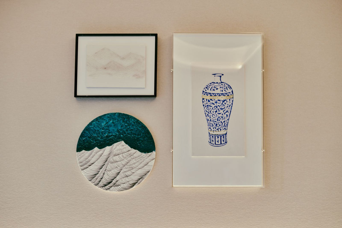 Mur de cadres : plusieurs tableaux composés ensemble sur un mur texturé