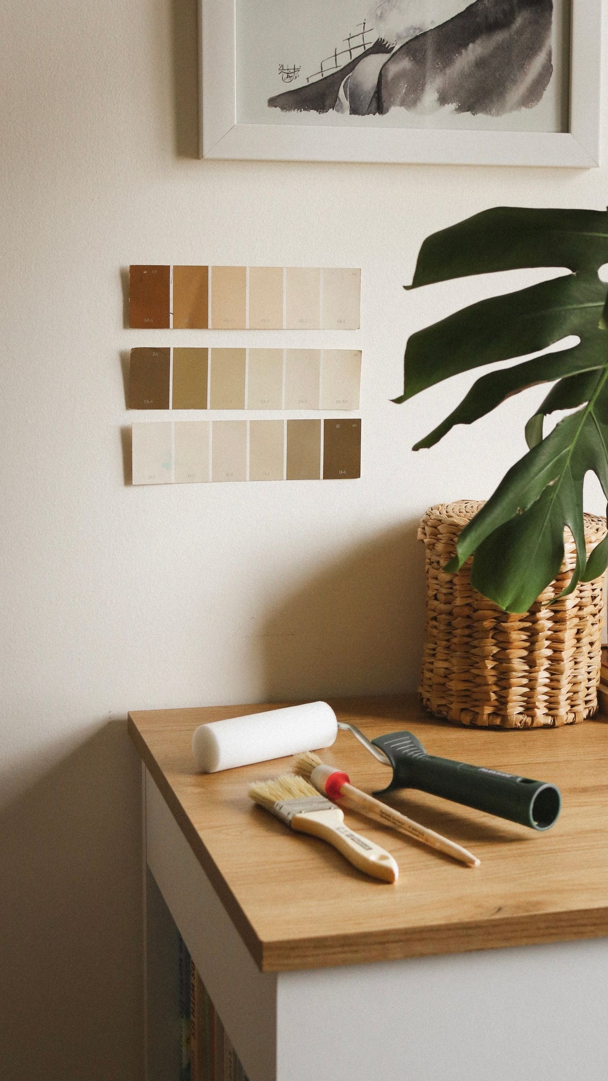 Nuancier de peinture, pinceaux et plante verte dans un intérieur chaleureux