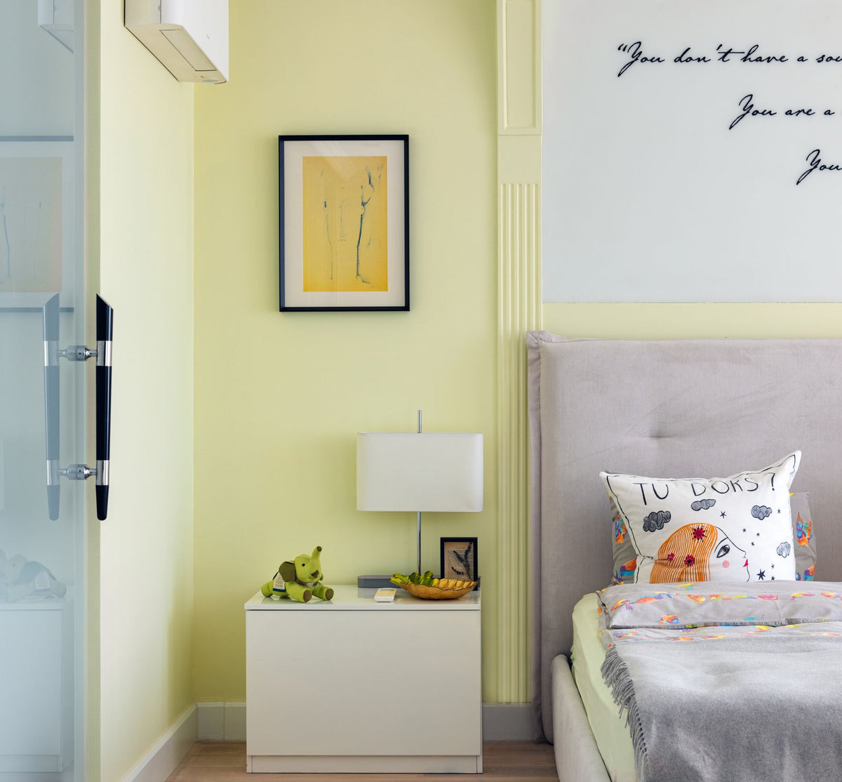 Chambre lumineuse avec un tableau encadré accroché au-dessus du lit